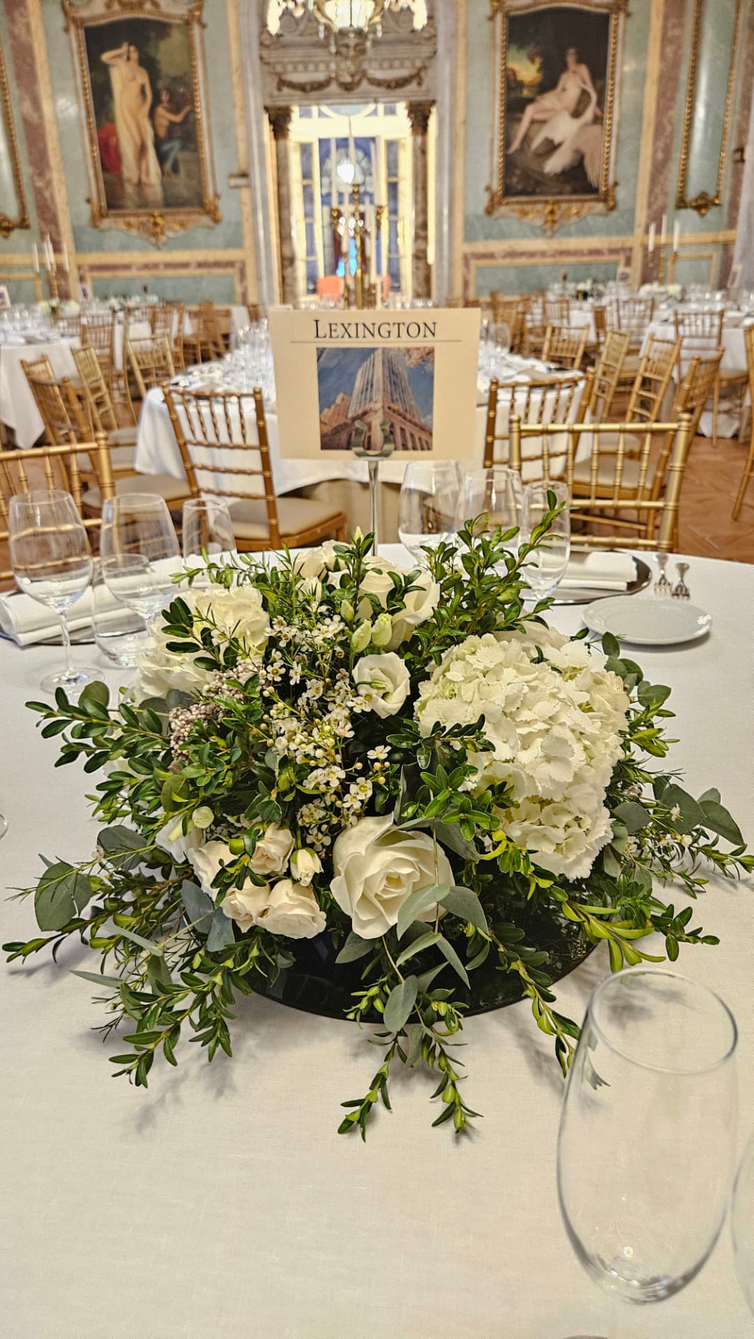 Centro de mesa de boda con rosas e hortensia blanca y follaje verde