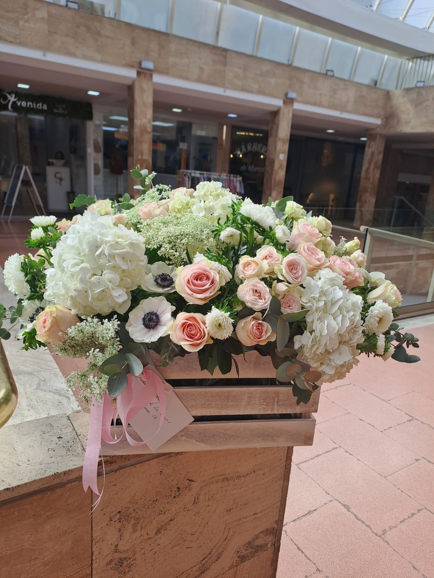 Centro floral en caja de madera con hortensias blancas, rosas y anémonas
