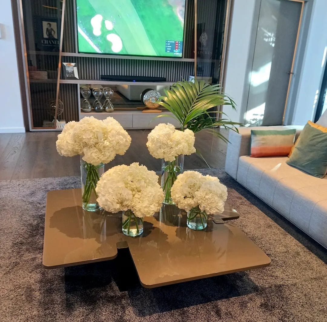 Composiciones de hortensias blancas en jarrones de cristal sobre una mesa de salón