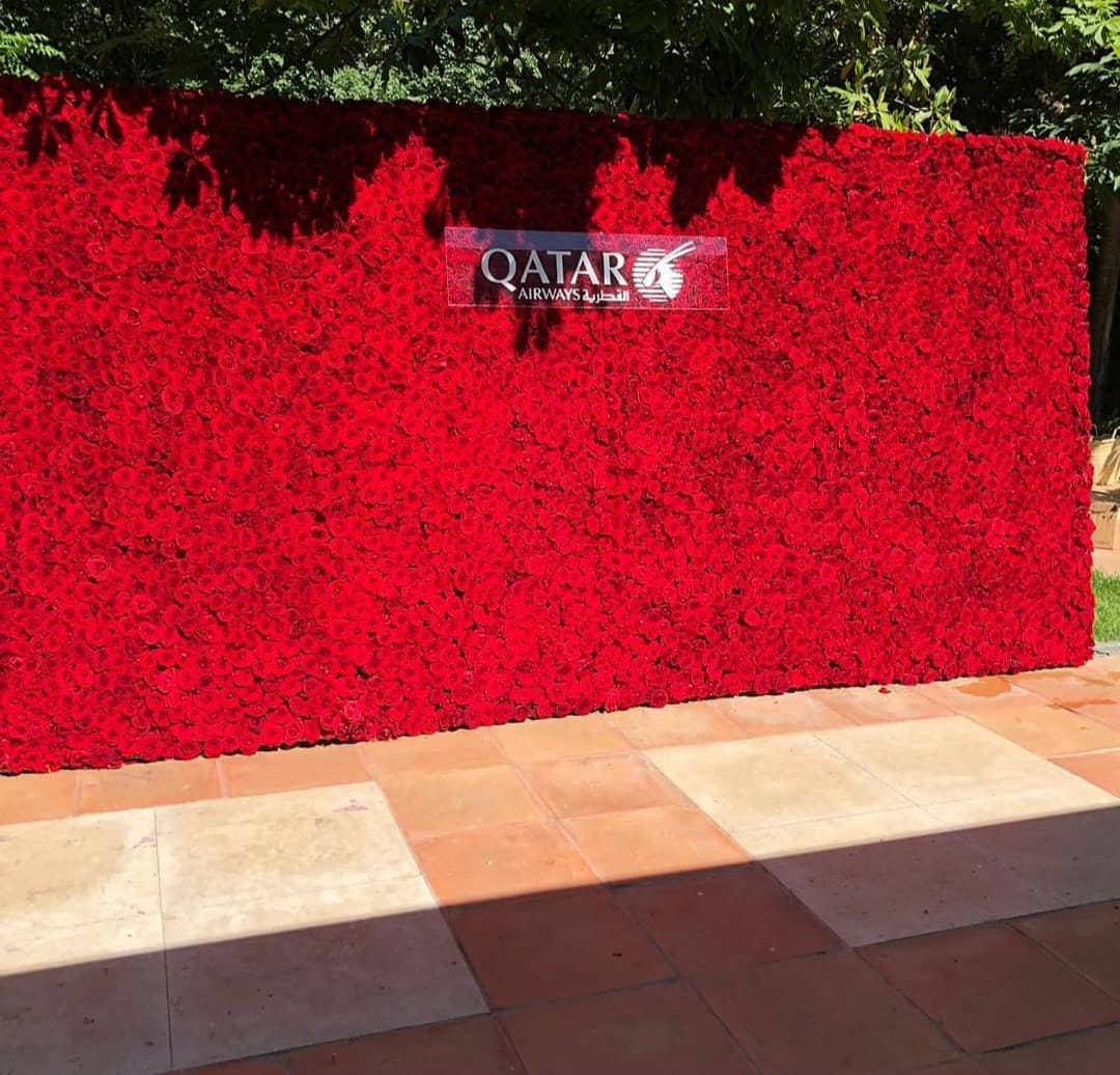 Muro de rosas rojas naturales montado en el exterior para un evento corporativo