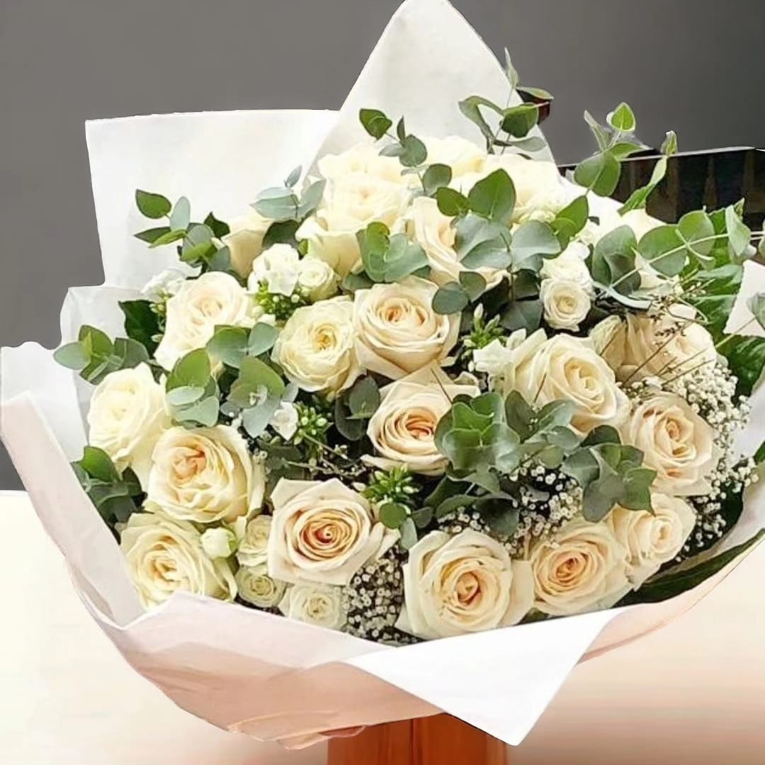 Ramo de rosas blancas con eucalipto y paniculata envuelto en papel blanco